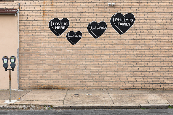 Brick wall with black candy hearts that say 